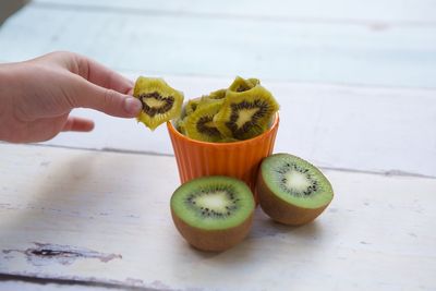 Close-up of hand holding fruit on table