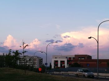 Cars on city street against sky