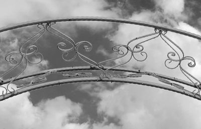 Low angle view of metal fence against sky