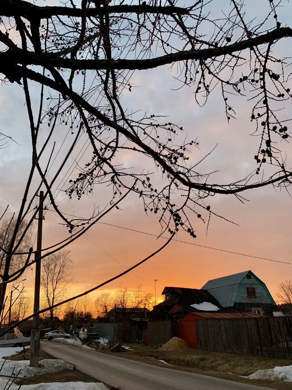 HOUSES BY STREET AGAINST SKY AT SUNSET