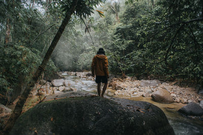 Male traveller explore the beautiful of rainforest stream in the morning.male traveller camping.
