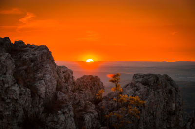Scenic view of rocks against orange sky