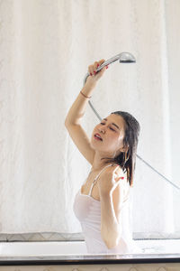 Woman wearing hat against wall at home