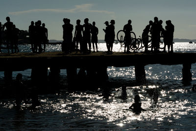 Young people, in silhouette, are seen having fun on the crush bridge in the late afternoon 