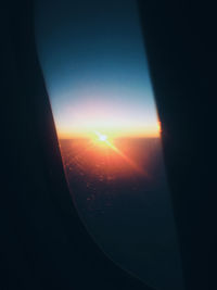 Close-up of airplane wing against sky during sunset