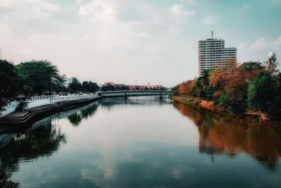 Scenic view of river by buildings against sky