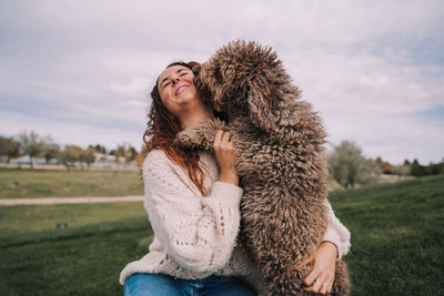 Smiling woman playing with dog