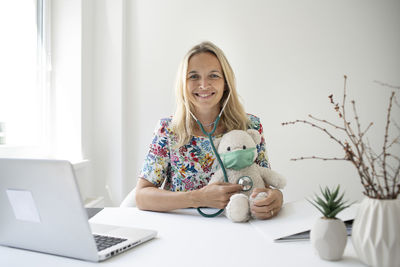 Portrait of smiling young woman using laptop at home