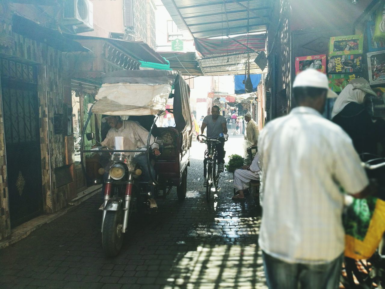 REAR VIEW OF PEOPLE AT MARKET