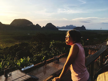 Woman looking at view while standing in balcony