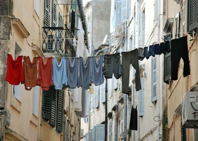 Clothes drying on rope amidst buildings in city