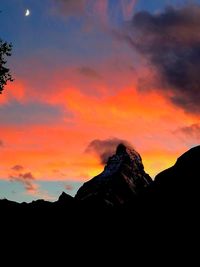 Silhouette mountains against orange sky