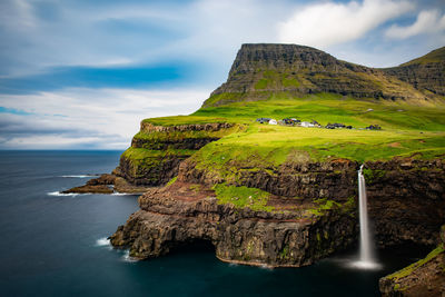 Scenic view of rock formation by sea against sky