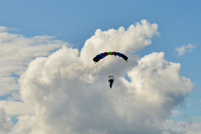 Low angle view of man paragliding against sky