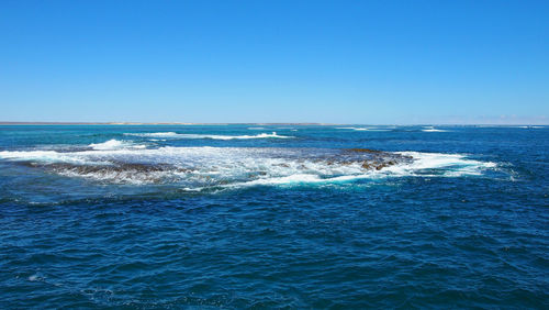 Scenic view of sea against clear blue sky