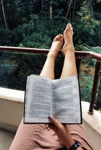 Low section of woman holding book