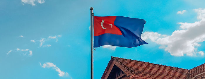 Low angle view of flag against blue sky