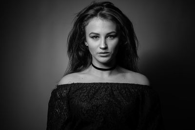 Portrait of beautiful woman standing against wall