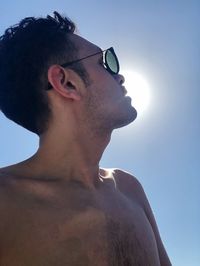 Low angle view of shirtless man against clear sky