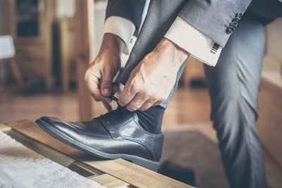 Low section of man tying shoes