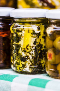 Close-up of pickles in glass jars on table