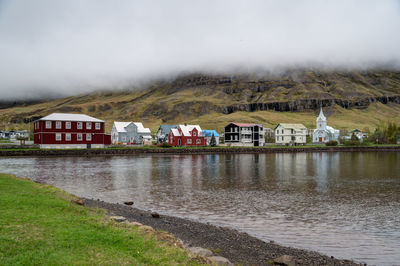 Houses by lake against sky