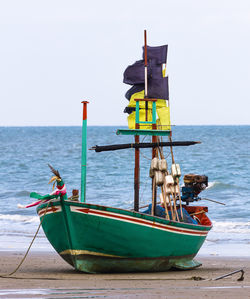 Ship moored on beach against clear sky