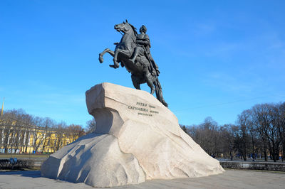 Low angle view of statue against blue sky