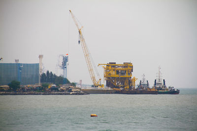 Commercial dock by sea against sky