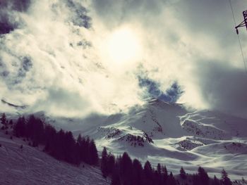 Snow covered mountains against cloudy sky