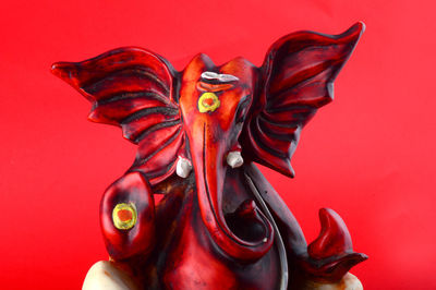 Close-up of statue against red background