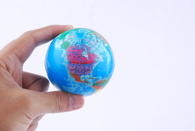 Close-up of hand holding glass against white background