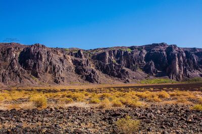 Scenic view of land against clear blue sky