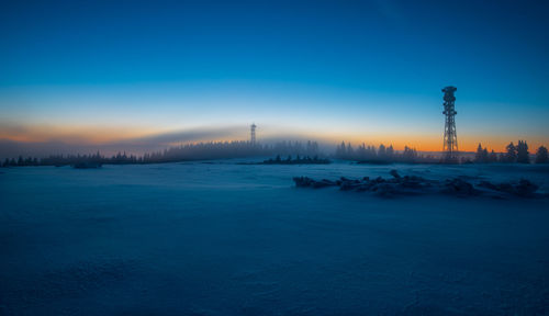 Scenic view of snow covered field against sky during sunset