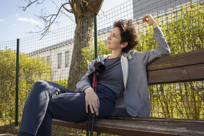 Pretty woman sits on bench holding sticks after nordic walking. beautiful happy caucasian woman