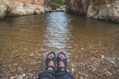 Low section of person on rock at beach