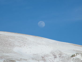 Low angle view of moon in blue sky