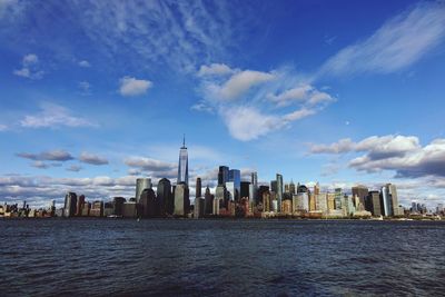 Scenic view of river by buildings against sky