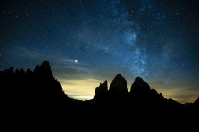 Low angle view of silhouette mountain against sky at night