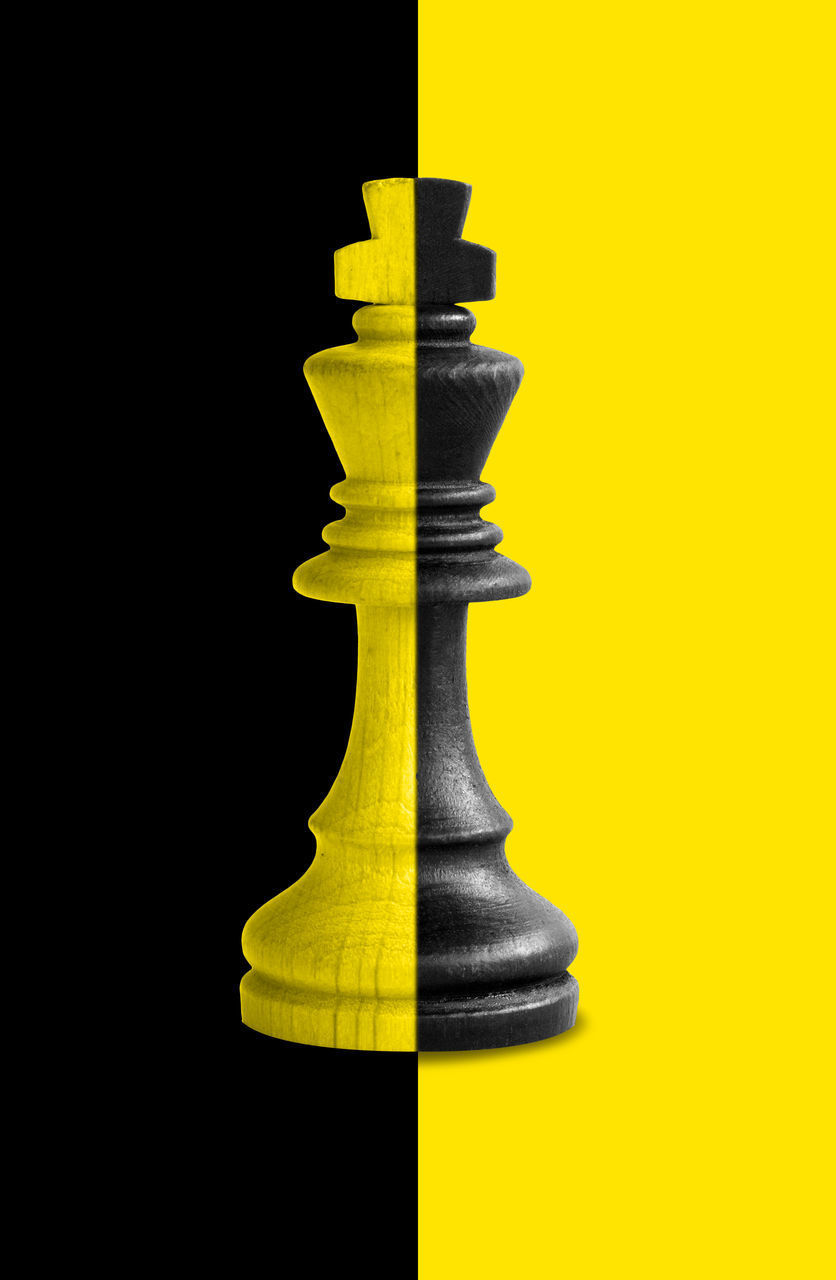 LOW ANGLE VIEW OF CHESS PIECES AGAINST BLACK BACKGROUND