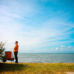 Man standing by sea against sky