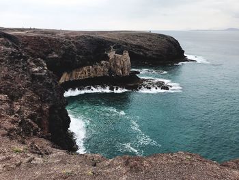 Scenic view of rocks in sea against sky