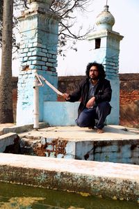 Full length of young man standing against building