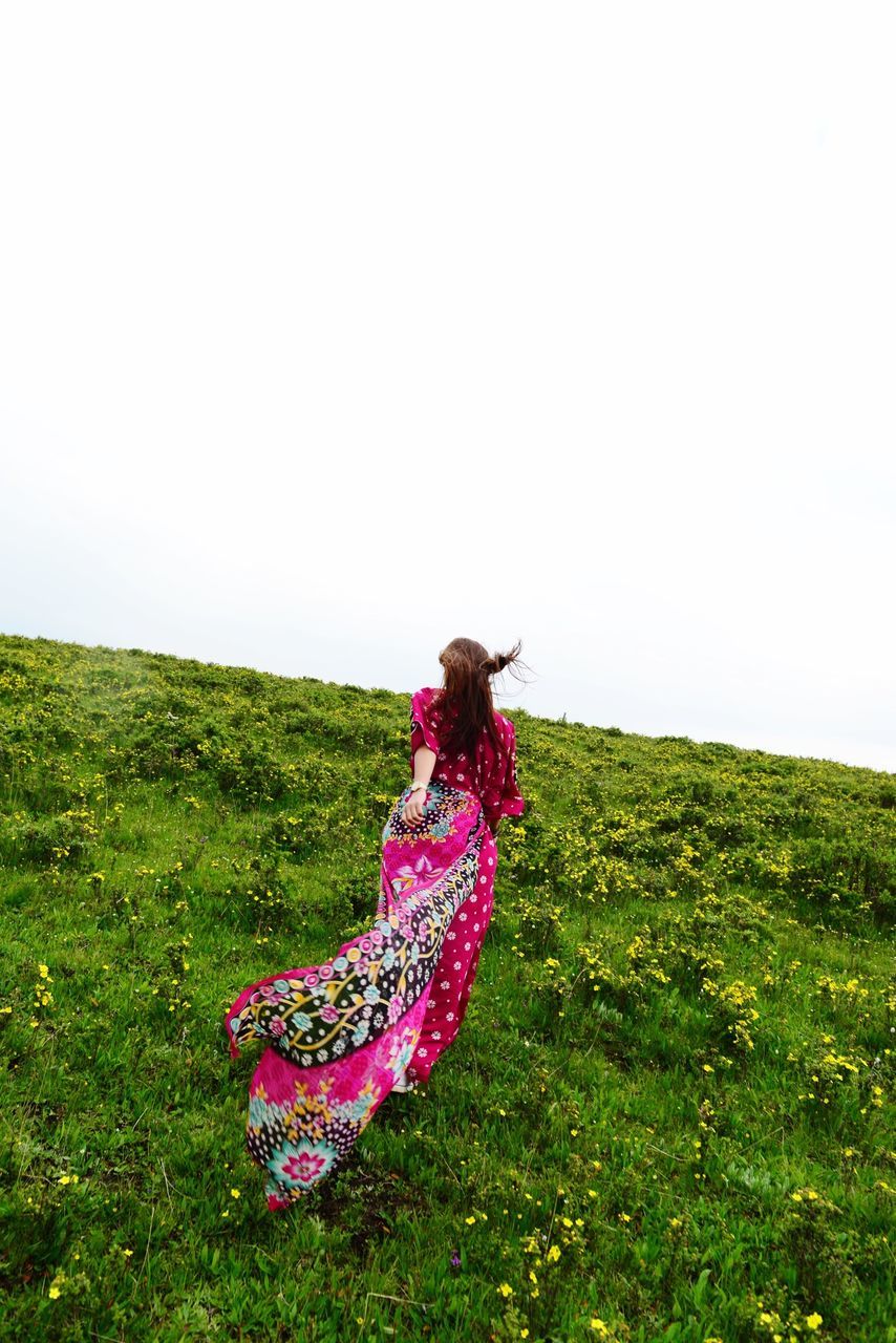 grass, field, leisure activity, clear sky, grassy, lifestyles, copy space, landscape, full length, green color, nature, beauty in nature, casual clothing, tranquility, tranquil scene, growth, day, sky