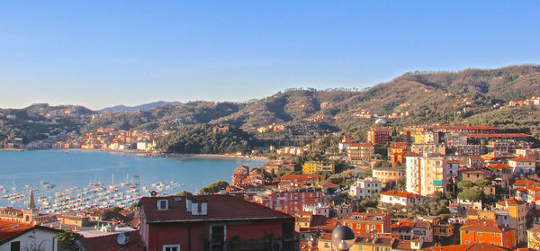 High angle view of townscape by sea against clear sky