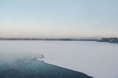 Scenic view of frozen lake against sky during winter