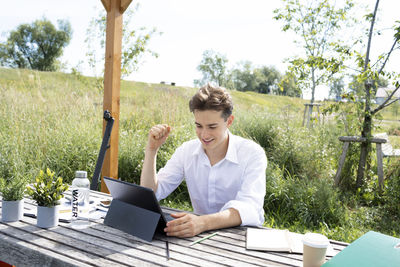 Portrait of young woman using laptop at table