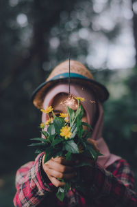 Close-up of hand holding flowering plant