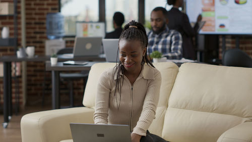 Smiling businesswoman working on laptop in office