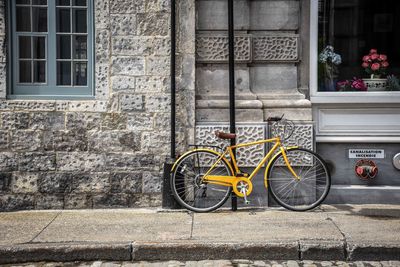 Bicycle on sidewalk against building in city
